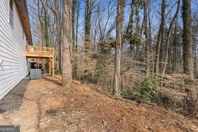 view of yard with central AC and a deck