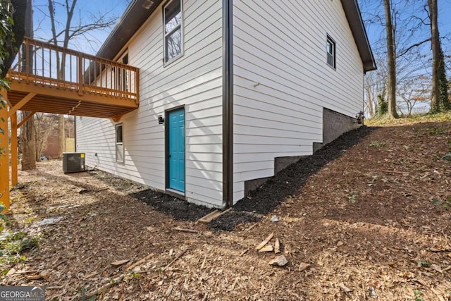 view of side of home with a wooden deck and central AC unit