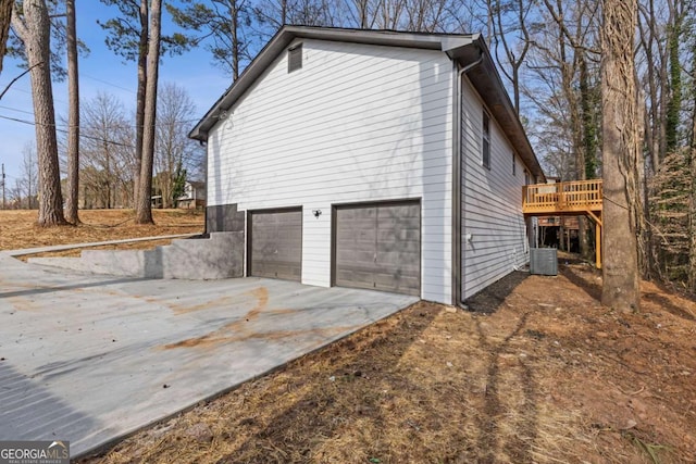 view of property exterior featuring a wooden deck, a garage, and central AC