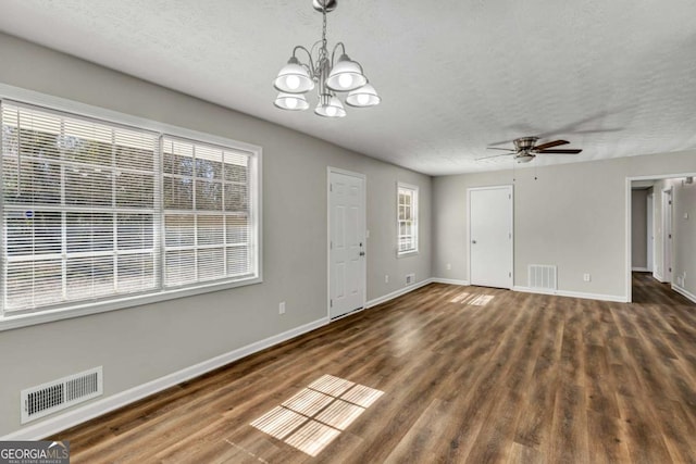 interior space with dark hardwood / wood-style floors, ceiling fan with notable chandelier, and a textured ceiling