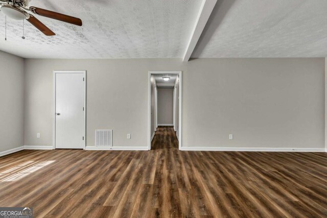 interior space with ceiling fan, dark hardwood / wood-style floors, and a textured ceiling