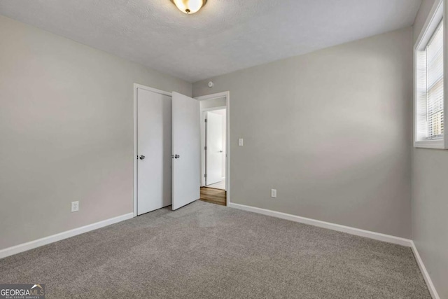 unfurnished bedroom with carpet and a textured ceiling