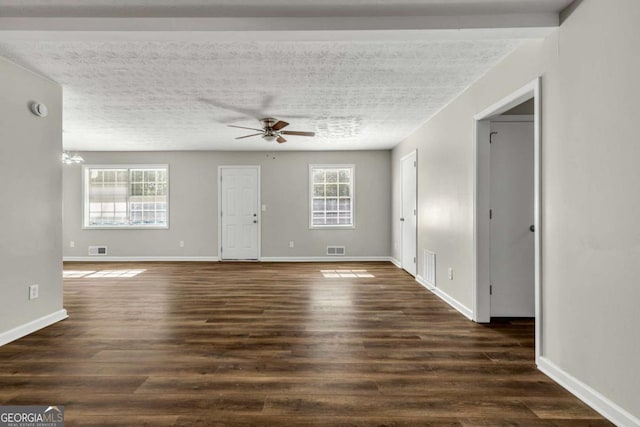 unfurnished room with ceiling fan, a textured ceiling, and dark hardwood / wood-style flooring