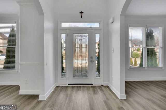 foyer with crown molding and light hardwood / wood-style flooring