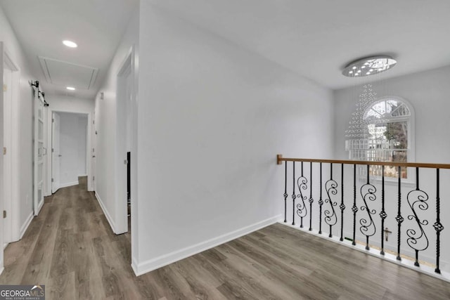 hall with hardwood / wood-style flooring and a notable chandelier