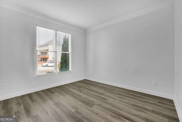 empty room featuring ornamental molding and dark hardwood / wood-style flooring