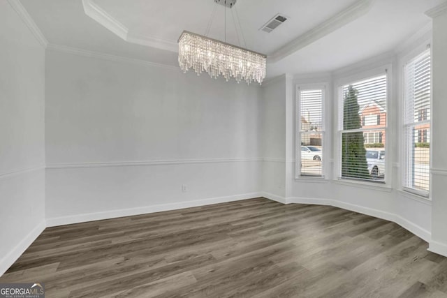 unfurnished dining area featuring a chandelier, ornamental molding, dark hardwood / wood-style flooring, and a raised ceiling