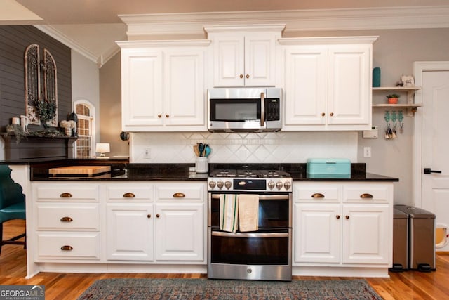 kitchen featuring ornamental molding, appliances with stainless steel finishes, and white cabinets