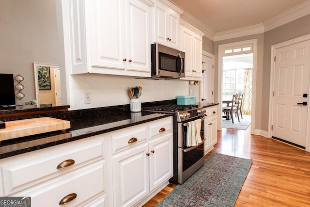 kitchen with crown molding, appliances with stainless steel finishes, and white cabinets