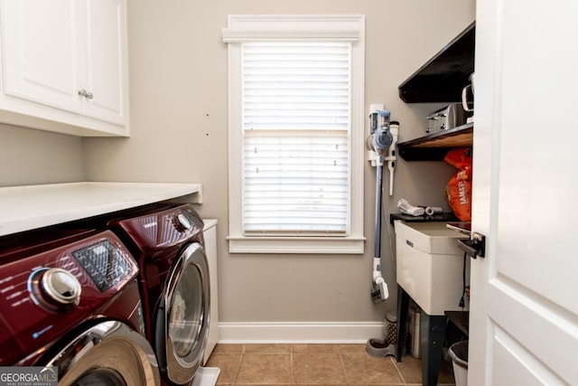 laundry room featuring cabinets, washing machine and dryer, and light tile patterned floors