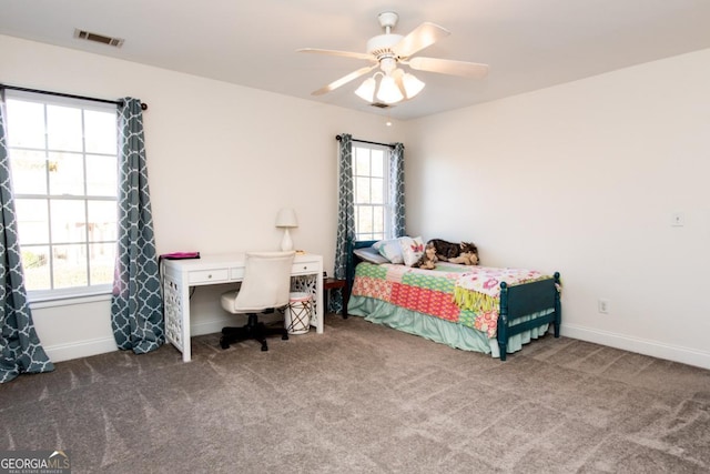 bedroom featuring ceiling fan, carpet floors, and multiple windows