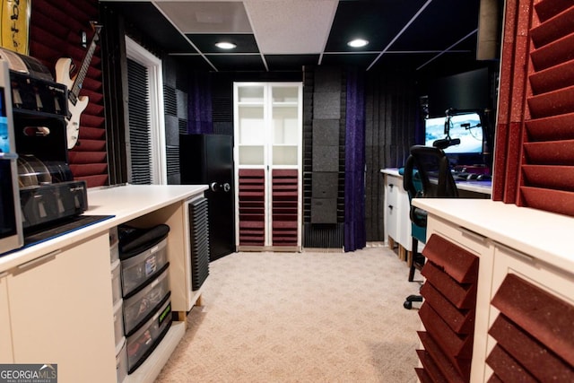 kitchen with a paneled ceiling and light carpet