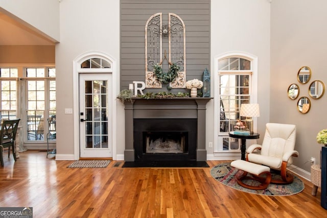 sitting room featuring hardwood / wood-style flooring and a towering ceiling