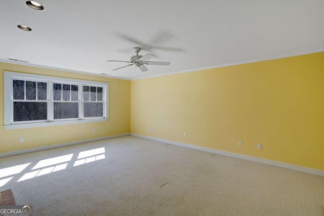 carpeted spare room featuring ceiling fan and ornamental molding