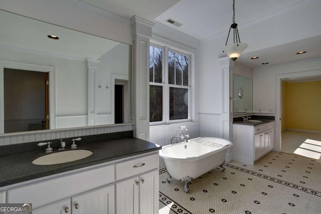 bathroom featuring crown molding, vanity, and a tub to relax in