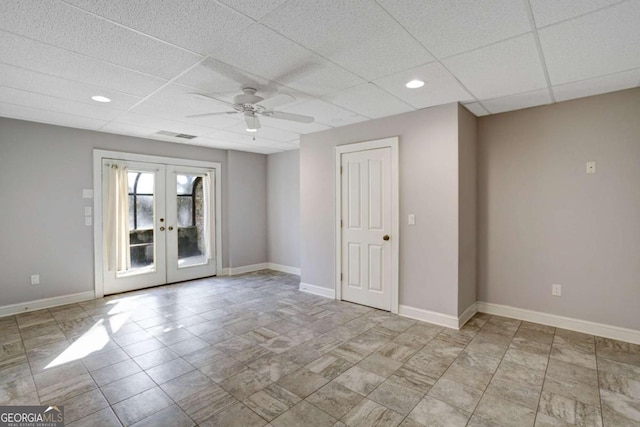 spare room with a paneled ceiling, ceiling fan, and french doors