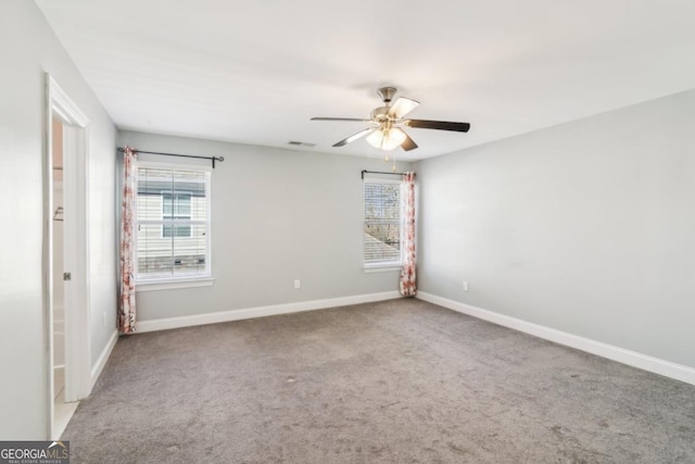 carpeted spare room featuring ceiling fan