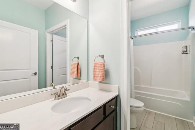 full bathroom featuring shower / tub combination, vanity, hardwood / wood-style flooring, and toilet