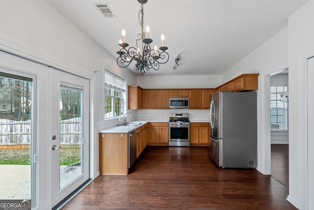 kitchen with stainless steel appliances, sink, pendant lighting, and dark hardwood / wood-style floors