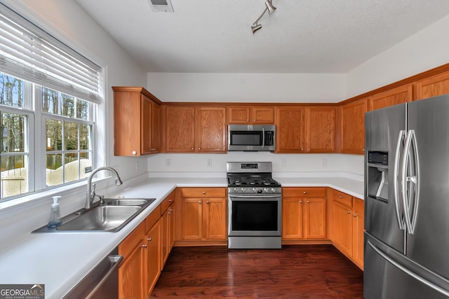 kitchen featuring sink, stainless steel appliances, dark hardwood / wood-style floors, and a textured ceiling