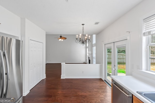 unfurnished dining area featuring dark hardwood / wood-style flooring, french doors, and an inviting chandelier