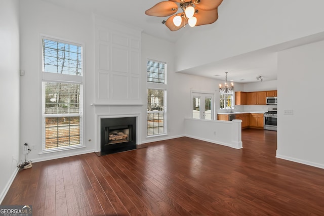 unfurnished living room featuring a healthy amount of sunlight, a fireplace, and dark hardwood / wood-style flooring