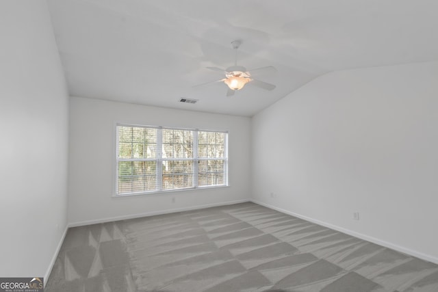 carpeted spare room with vaulted ceiling and ceiling fan