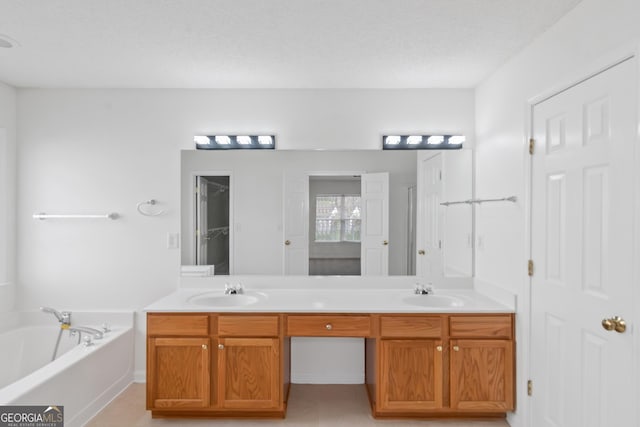 bathroom with vanity, a tub, and a textured ceiling