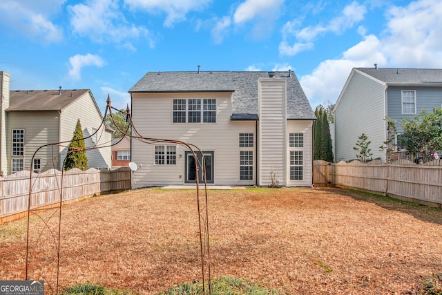 rear view of house with a patio and a yard