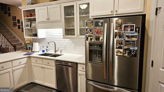 kitchen with decorative backsplash, stainless steel appliances, light countertops, open shelves, and a sink