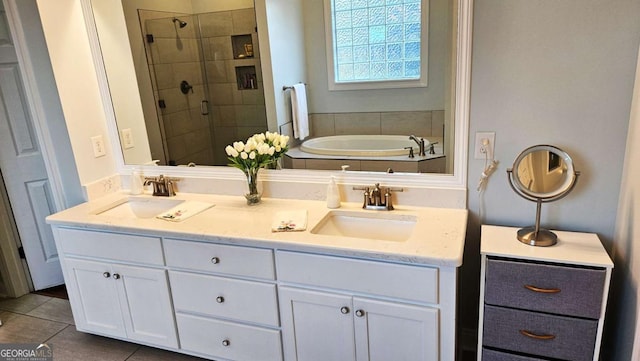 full bath featuring double vanity, tile patterned floors, a sink, and a shower stall