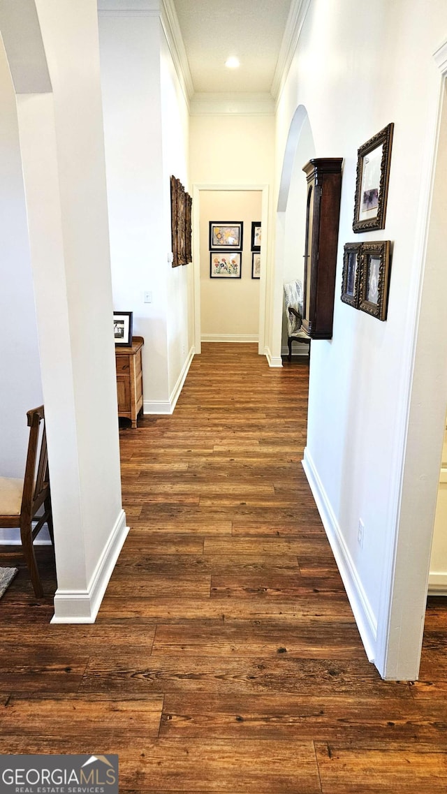 hall with dark wood-style floors, arched walkways, recessed lighting, ornamental molding, and baseboards