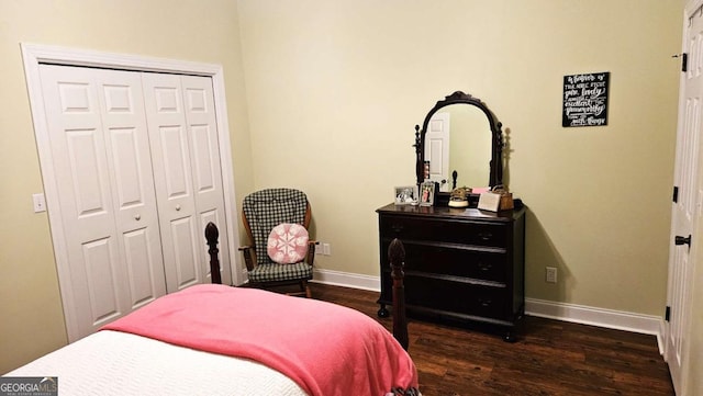 bedroom featuring baseboards, dark wood-style flooring, and a closet