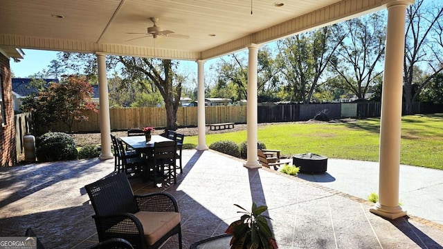 view of patio featuring outdoor dining area, a fenced backyard, ceiling fan, and a fire pit