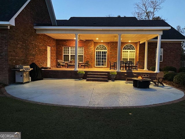 rear view of property featuring an outdoor fire pit, a patio area, and brick siding