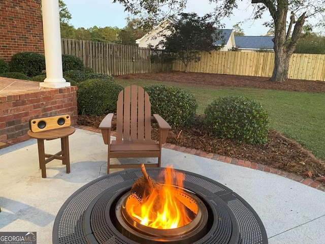 view of patio featuring a fire pit and fence