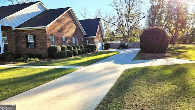 view of property exterior featuring brick siding, a lawn, and fence