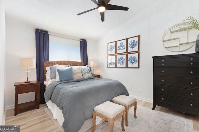 bedroom featuring vaulted ceiling, light hardwood / wood-style floors, and ceiling fan