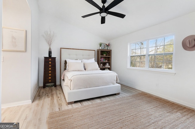 bedroom with ceiling fan, vaulted ceiling, and light hardwood / wood-style flooring