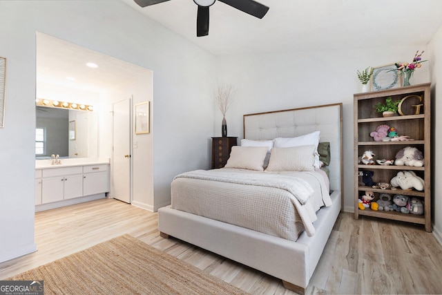 bedroom featuring ceiling fan, ensuite bathroom, sink, and light hardwood / wood-style floors