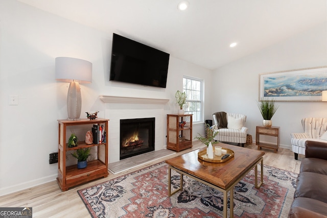 living room featuring lofted ceiling and light hardwood / wood-style flooring