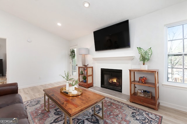 living room featuring light hardwood / wood-style flooring, a wealth of natural light, and vaulted ceiling