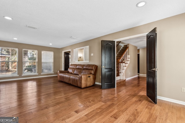 living room with hardwood / wood-style flooring and a textured ceiling