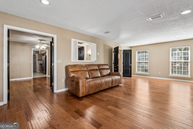 living room featuring wood-type flooring and a textured ceiling