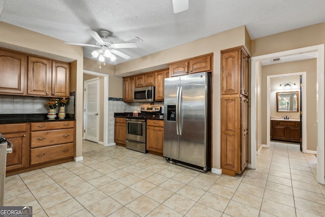 kitchen with tasteful backsplash, sink, ceiling fan, and appliances with stainless steel finishes