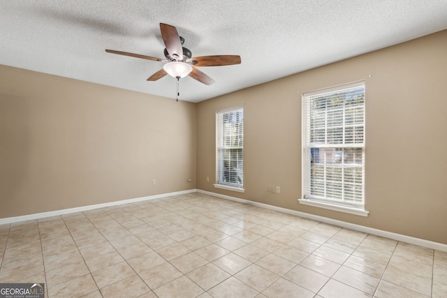 spare room with light tile patterned floors, a textured ceiling, and ceiling fan