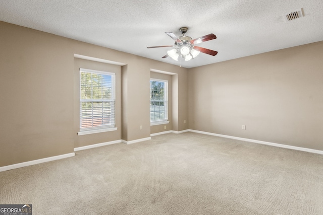 empty room with a textured ceiling, carpet floors, and ceiling fan