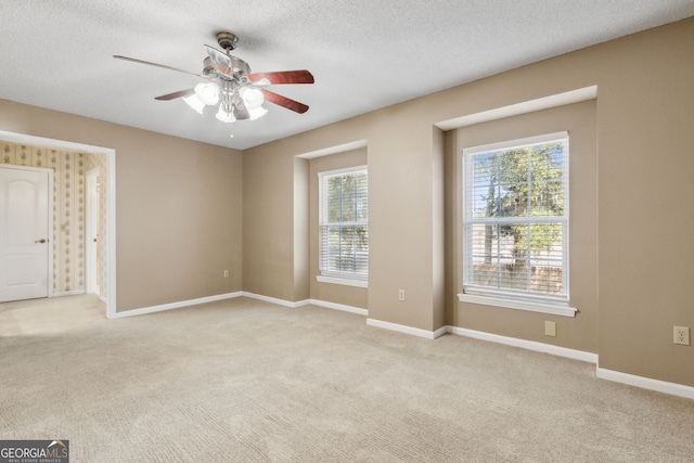 carpeted empty room featuring ceiling fan and a textured ceiling