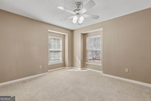 carpeted spare room with ceiling fan and a textured ceiling