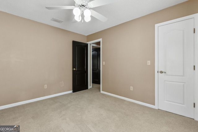 unfurnished bedroom with light colored carpet and ceiling fan